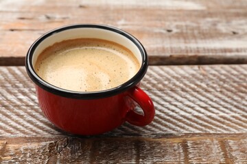 Cup of aromatic coffee on wooden table, closeup. Space for text