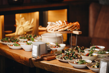 Beautifully decorated catering banquet table with different food snacks and appetizers with sandwich, caviar, fresh fruits on corporate christmas birthday party event or wedding celebration.
