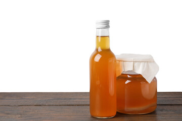 Delicious kombucha in glass bottle and jar on wooden table against white background, space for text