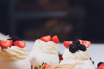 Dessert with berries on a meringue with cream.