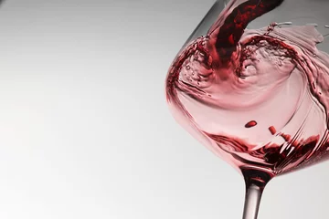  Pouring tasty red wine in glass on white background, closeup. Space for text © New Africa