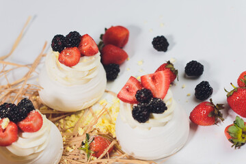 Dessert with berries on a meringue with cream.