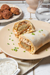 Shawarma with greens and falafel cutlets on a light background