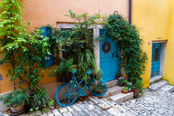 Fototapeta na wymiar cityscape grisia street view in Rovinj Croatia with yellow houses and blue doors and bicycle decoration