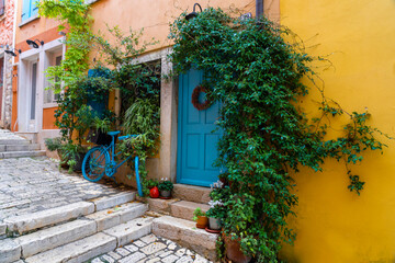 cityscape grisia street view in Rovinj Croatia with yellow houses and blue doors and bicycle decoration