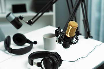 Modern office studio equipment microphone setting, laptop, tablet and headphone prepared with coffee on live streaming with empty host channel steamer podcast social media online concept. Postulate.