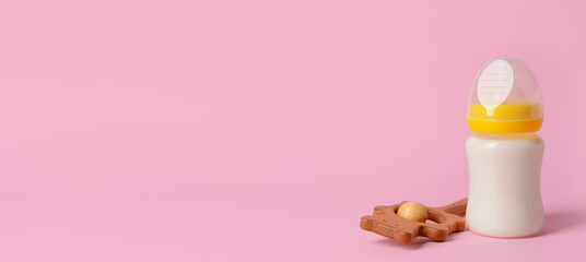 Bottle of milk for baby and toy on color background