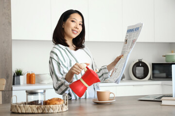Beautiful young Asian woman pouring espresso from geyser coffee maker into cup and reading...