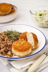 Plate of tasty meat cutlets with buckwheat on white background