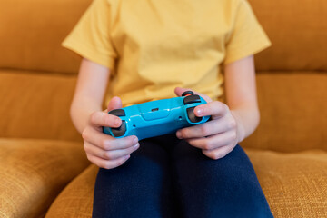 Child holding a game controller sitting on a sofa