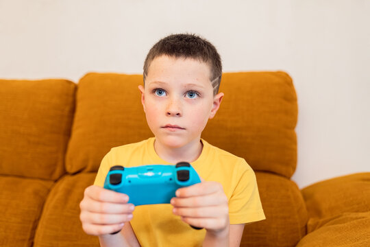 Young gamer playing intensely on a brown couch