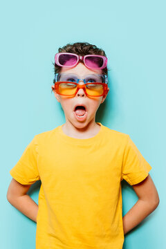 Young boy amazed wearing multiple sunglasses