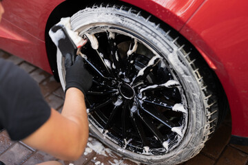 Car detailing: close-up of hand washing a tire
