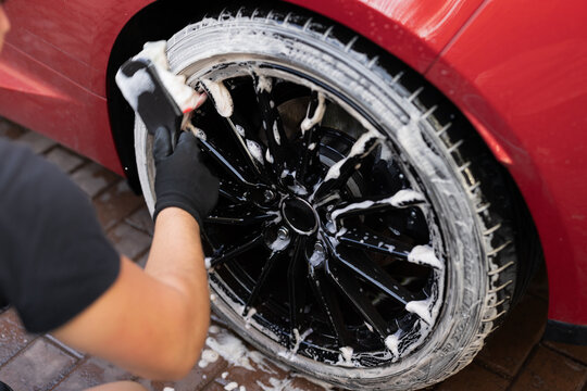 Car detailing: close-up of hand washing a tire
