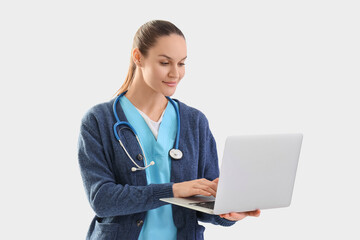 Female medical intern using laptop on white background