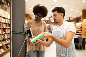 Two people scanning a book in a bookstore