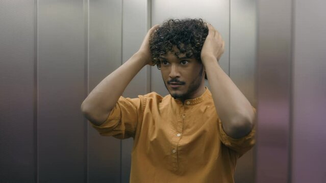 Arabian Indian business man looking self reflection at mirror preening inside elevator lift confident handsome guy male employee successful businessman smile pampering prepare for work day in office