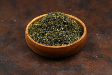 Green  tea with herbs in wooden bowl on a wooden board