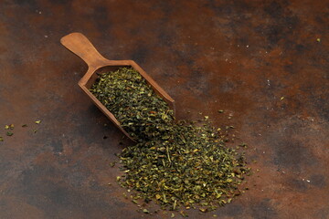 Green  tea with herbs in wooden spoons on a wooden board