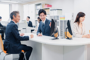 窓口でお客様の対応をするビジネスウーマン
