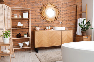 Modern interior of bathroom with brick wall
