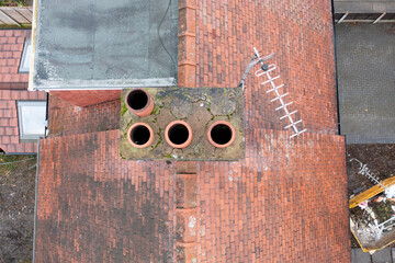 Aerial photo of a typical British terrace house in the UK showing the roof of the house and the chimney in the winter time