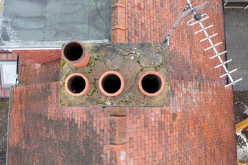 Aerial photo of a typical British terrace house in the UK showing the roof of the house and the chimney in the winter time