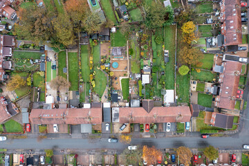 Aerial drone photo of a typical British terrace house in the UK showing the roof of the house and the large garden in the winter time