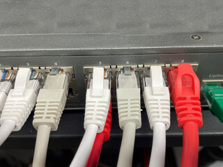 Modern white and red cat 5 ethernet cables plugged into router system
