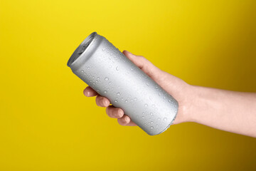 Woman with energy drink on yellow background, closeup