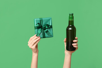 Hands with beer and gift on green background. St. Patrick's Day celebration