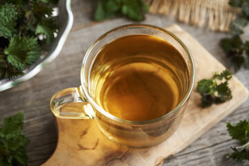 Nettle tea in a glass cup in springtime