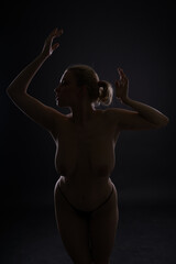 Low key portrait of beautiful female body on dark background