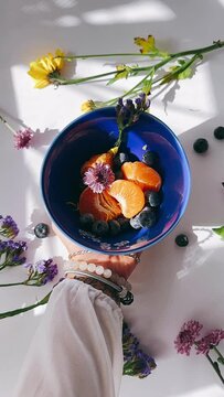 pov, woman's hands, fruit bowl, vibrant flowers, colorful mix, healthy eating, breakfast spread, brunch vibes, summer vibes, fresh produce, seasonal fruits, overflowing bowl, inviting, tempting, delic