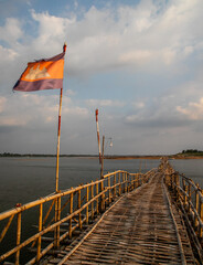 cambodian flag on old traditional bamboo wooden bridge across Mekong river (from Koh Paen island to...