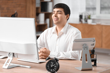 Young businessman working at table in office. Time management concept