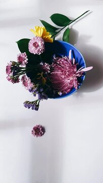 blue bowl, floral arrangement, overhead shot, down shot, vibrant flowers, colorful blooms, summer flowers, spring flowers, centerpiece, table decoration, interior design, living room, dining room, kit