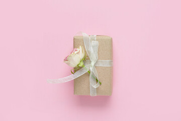 Gift box with beautiful rose on pink background. International Women's Day