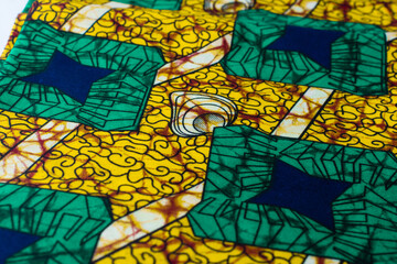 top view of green ankara fabric, flatlay of nigerian wax cloth with designs, spread out green...