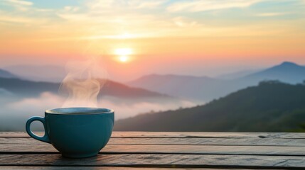 Close-up view of a cup of coffee on table with sunrise over mountain ridge with fog.