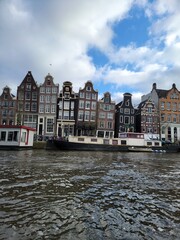 "Dancing Houses" are crooked historic houses located at Damrak. Amsterdam, Netherlands