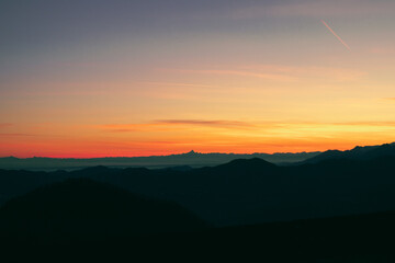 Staring at the horizon, orange afterglow. Suggestive view of the Alps, with Monviso mountain stands...