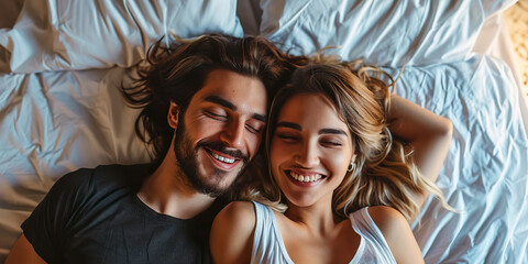 Happy beautiful couple lying together on the bed