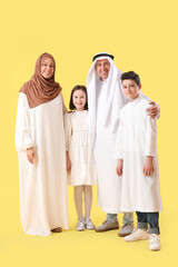 Happy Muslim family on yellow background. Eid al-Fitr celebration