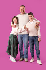 Happy Muslim father and his children with prayer beads on pink background. Eid al-Fitr celebration