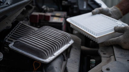 The master changes the air filter in the car engine. 