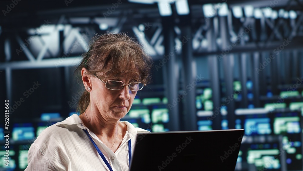 Poster aged employee in server hub equipped to handle modern computing requirements, doing regular upgrades