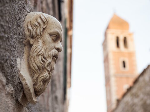 Stone relief, sculpture, behind church tower, face of a man, old town centre of Rab, town of Rab, island of Rab, Kvarner Gulf Bay, Croatia, Europe