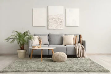 Foto op Canvas Interior of modern living room with cozy sofa, pictures and coffee table © Pixel-Shot