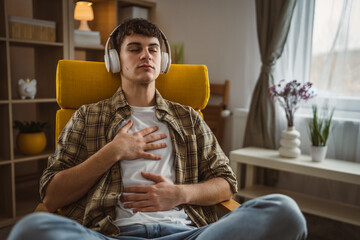 Fototapeta premium One teen man doing guided meditation yoga self care practice at home